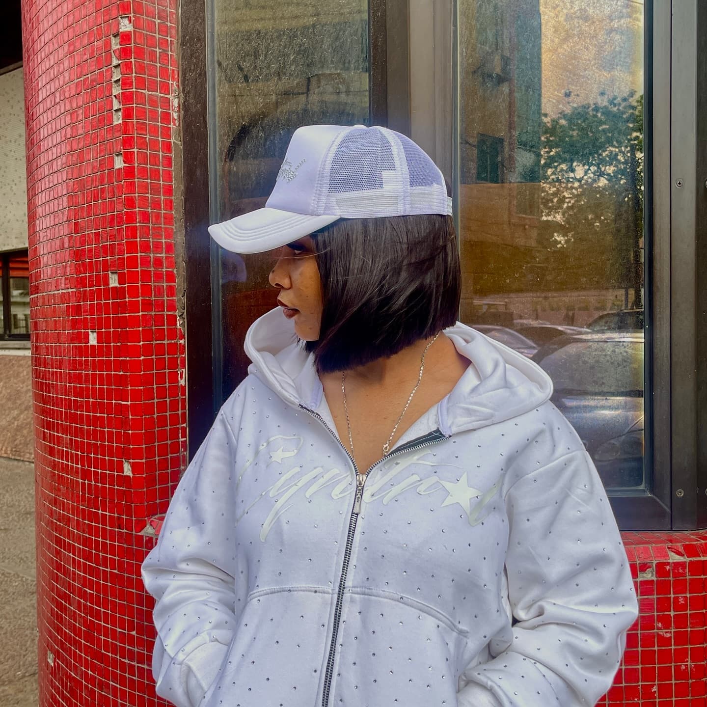 White hoodie profile by red tile wall